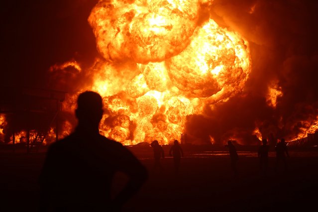 Flames rise after a massive fire broke out at the asphalt storage facility of an oil refinery located on Erbil-Gwer road in Iraq on June 12, 2024. Firefighter teams respond to the flames. (Photo by Ahsan Mohammed Ahmed Ahmed/Anadolu via Getty Images)