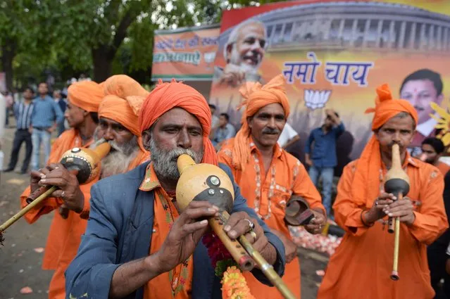 A band of Indian musicians plays music for a group of paying customers who wanted to dance as they celebrate at the Bharatiya Janata Party (BJP) headquarters in New Delhi on May 16, 2014. India's triumphant Hindu nationalists declared “the start of a new era” in the world's biggest democracy after hardline BJP leader Narendra Modi propelled them to a stunning win on a platform of revitalizing the sickly economy. (Photo by Roberto Schmidt/AFP Photo)