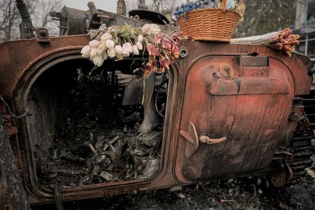 Flowers lay on a Ukrainian military armored fighting vehicle destroyed during fighting between Russian and Ukrainian forces on the outskirts of Kyiv, Ukraine, Friday, April 1, 2022. (Photo by Vadim Ghirda/AP Photo)