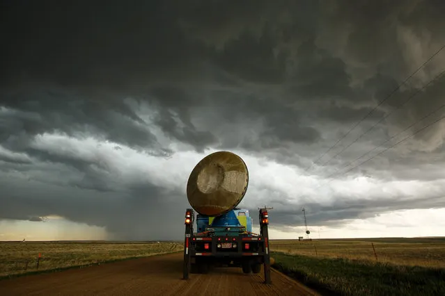 The Doppler on Wheels (DOW) vehicle scans a supercell thunderstorm during a tornado research mission, May 8, 2017 in Elbert County near Agate, Colorado. Doppler on Wheels (DOW) is a mobile doppler radar mounted on a truck that brings instruments directly into storms, allowing scientists to scan storms and tornadoes and make 3-D maps of wind and debris. With funding from the National Science Foundation and other government grants, scientists and meteorologists from the Center for Severe Weather Research try to get close to supercell storms and tornadoes trying to better understand tornado structure and strength, how low-level winds affect and damage buildings, and to learn more about tornado formation and prediction. (Photo by Drew Angerer/Getty Images)