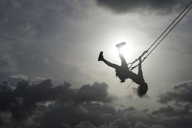 A woman swings on a swing in Venao beach in Pedasi, Panama, Saturday, July 13, 2024. (Photo by Matias Delacroix/AP Photo)