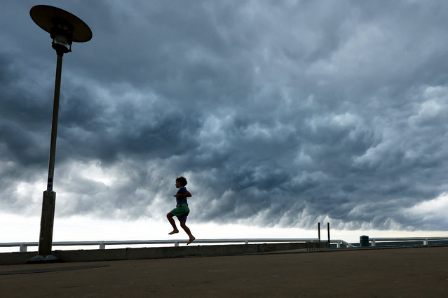 A child plays as storm clouds move over Nobbys Beach on November 09, 2023 in Newcastle, Australia. There is a severe thunderstorm warning, which includes potential heavy rainfall and flash flooding over the next several hours in parts of the Hunter, Central Tablelands, North West Slopes and Plains and Central West Slopes and Plains districts. (Photo by Mark Evans/Getty Images)