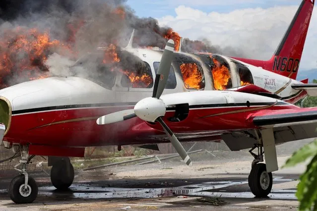 A plane belonging to U.S. missionary group Agape Flights burns after it was set on fire during protests demanding that the government of Prime Minister Ariel Henry do more to address gang violence including constant kidnappings, in Les Cayes, Haiti on March 29, 2022. (Photo by Duples Plymouth/Reuters)