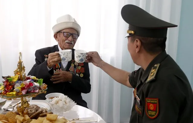 World War II veteran Turkonakun Beishembaev (L) with Kyrgyz Defense Minister Baktybek Bekbolotov at home in Bishkek, Kyrgyzstan, 06 May 2022. 98-year-old Turkonakun Beishembaev was awarded the Order of the Great Patriotic War. Kyrgyzstan marks Victory Day annually on 09 May celebrating the victory of the Soviet Union's Red Army over Nazi Germany in World War II. (Photo by Igor Kovalenko/EPA/EFE)