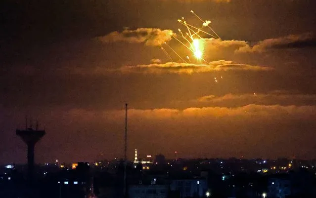Israeli Iron Dome missiles intercept incoming missiles fired from the Gaza Strip above the Palestinian enclave, on April 21, 2022. Palestinian militants fired volleys of rockets from Gaza into Israel, which responded with air strikes in the early hours in the biggest escalation since an 11-day war last year. (Photo by Said Khatib/AFP Photo)