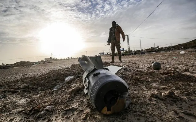 A Palestinian fighter from Ezz-Al Din Al-Qassam Brigades, the armed wing of the Hamas movement, checks debris at the site of an Israeli air strike in Khan Yunis in the southern Gaza Strip on December 26, 2019. (Photo by Said Khatib/AFP Photo)