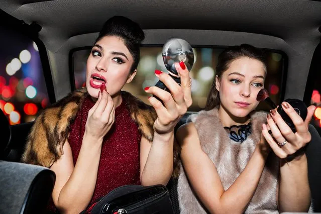 Women touching up make up in car at night time. (Photo by Betsie Van Der Meer/Getty Images)