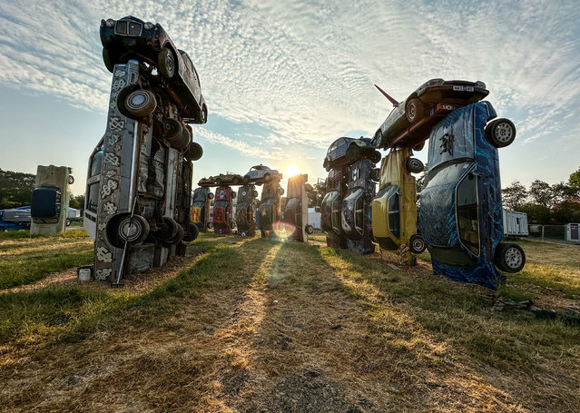 Undated handout photo issued by Carhenge Glastobury of the Carhenge installation by artist Joe Rush, on the site of Glastonbury Festival at Worthy Farm in Somerset. Made of 24 vintage cars erected in the centre of the festival, the installation emulates the ancient stone structure at Stonehenge. Issue date: Tuesday, June 20, 2023. (Photo by Matt Cardy/PA Wire Press Association)