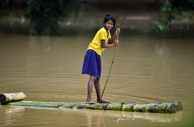 A girl floats on a makeshift raft made of banana tree wood in the flood-affected Nagaon district of Assam, India, 22 May 2022. Death toll of flood-related incidents increased to 18 people, according to statistics from the Assam State Disaster Management Authority (ASDMA). At least 839,691 people in 32 districts have been affected by the floods, the ASDMA added. (Photo by EPA/EFE/Stringer)