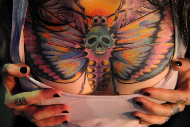 A woman shows off her tattoo during  during an International Congress of Tattoo Artists in Moscow, on May 18, 2012