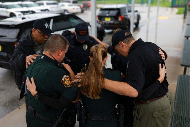 Members of the Polk County Sheriff's Office pray outside a shelter as Hurricane Milton approaches, in Lakeland, Florida, U.S., October 9, 2024. (Photo by Jose Luis Gonzalez/Reuters)