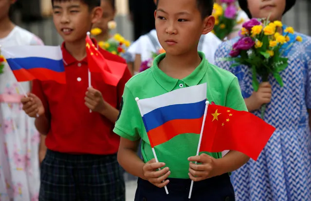 Children hold national flags of Russia and China prior to a welcoming ceremony for Russian President Vladimir Putin outside the Great Hall of the People in Beijing, China, June 25, 2016. (Photo by Kim Kyung-Hoon/Reuters)