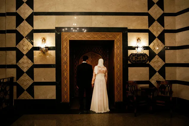 An Egyptian bride and groom prepare to enter a wedding hall to sign their religious wedding contract in Cairo, Egypt, Saturday, August 1, 2015. (Photo by Hassan Ammar/AP Photo)