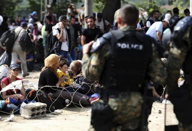 Macedonian special policemen guard the border as more than a thousand immigrants wait at the border line of Macedonia and Greece to enter Macedonia near the Gevgelija railway station August 21, 2015. (Photo by Ognen Teofilovski/Reuters)