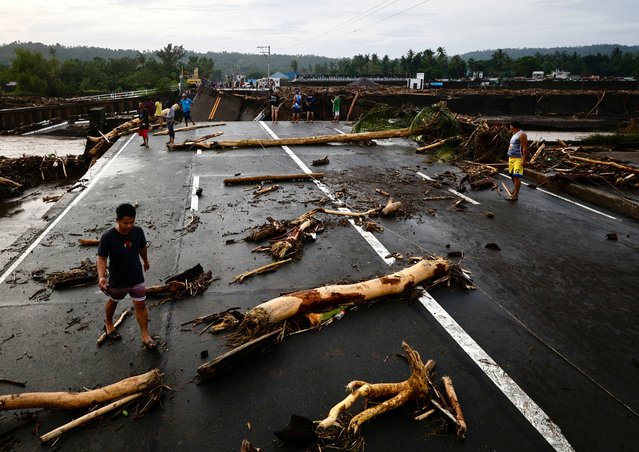 Villagers stand near a damaged bridge in the aftermath of Tropical Storm Trami, in the flood-hit town of Laurel, Batangas province, Philippines, 25 October 2024. At least 30 people were killed and more than 200,000 villagers fled their homes as Tropical Storm Trami barreled the Philippines, officials said on 25 October. Trami dumped heavy rain, triggering widespread flooding and landslides. (Photo by Francis R. Malasig/EPA/EFE)