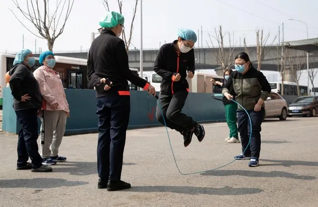 Medical workers wearing face masks jump rope as they take a break outside the hotel where they stay, in Wuhan, China March 5, 2020. (Photo by China Daily via Reuters)