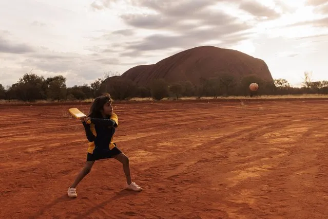 A child plays cricket during the ICC Men's T20 World Cup Trophy Tour at Mutitjulu on August 09, 2022 in Uluru, Australia. Mutitjulu is an Aboriginal Community located at the base of Uluru. (Photo by Brook Mitchell/Getty Images)