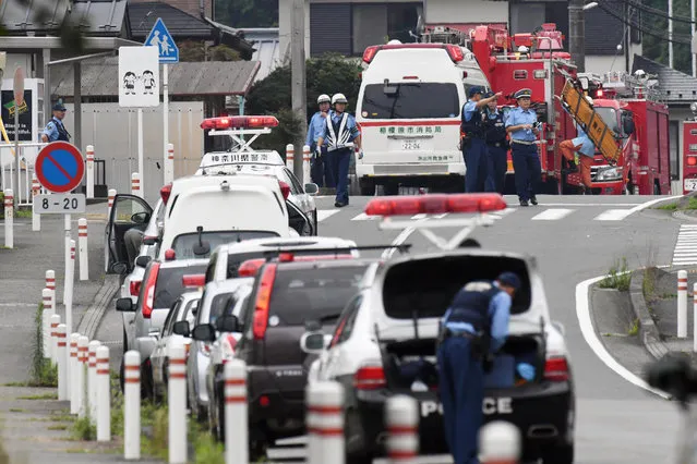 Police officers stand by with ambulances and firetrucks seen on a street near a facility for the handicapped where a number of people were killed and dozens injured in a knife attack Tuesday, July 26, 2016, in Sagamihara, outside Tokyo. (Photo by Kyodo News via AP Photo)