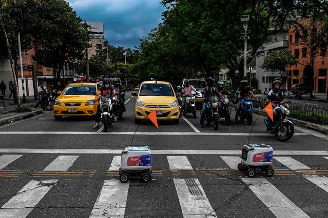 Two delivery robots cross a street in Medellin, Colombia, on April 22, 2020 during the novel coronavirus, COVID-19, pandemic. Colombian on-demand services start up Rappi is using wheeled robots designed by KiwiBot as a way of getting take out food to people who are forced stay home during lockdown as a preventive measure to slow the spread of COVID-19. (Photo by Joaquín Sarmiento/AFP Photo)