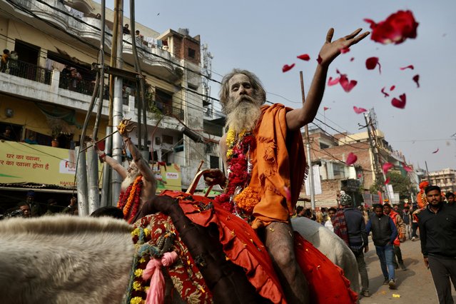 A Sadhu, or a Hindu holy man, throws flower petals on the devotees as he takes part in a religious procession of Niranjani Akhara, ahead of the Maha Kumbh Mela festival in Prayagraj on January 4, 2025. (Photo by Niharika Kulkarni/AFP Photo)