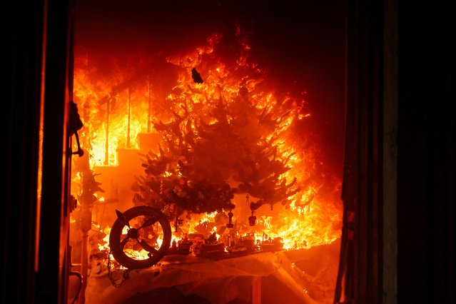 A Christmas tree burns amid the Eaton Fire in Altadena, on January 8, 2025. (Photo by David Swanson/Reuters)