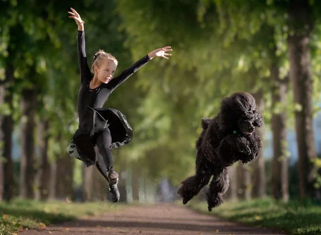 Nine-year-old Maria Palkina dancing with her black poodle. (Photo by Andrey Seliverstov/Caters News Agency)