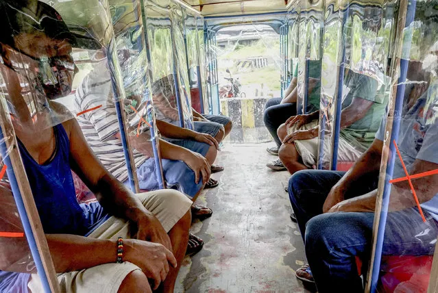 Filipino jeepney drivers show how safe distancing can be implemented inside their passenger jeepney through the use of plastic covers, wood and plastic pipes in Pasay, Philippines on June 08, 2020. For almost three months and counting, jeepney drivers have no income due to limits on public transportation as part of lockdown measures to combat COVID-19. Considered the Philippines' kind of the road, a jeepney is a popular transportation ubiquitous in the country. (Photo by Dante Diosina JR/Anadolu Agency via Getty Images)