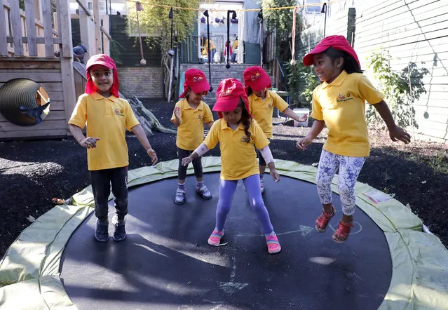 Children jump on a trampoline at the Little Darling home-based Childcare after nurseries and primary schools partly reopen in England after the COVID-19 lockdown in London, Monday, June 1, 2020. (Photo by Frank Augstein/AP Photo)