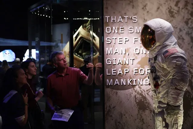 A visitor takes picture of the spacesuit that astronaut Neil Armstrong wore when he stepped on the surface of the moon on July 20, 1969 at the “Destination Moon” exhibit at The Smithsonian National Air and Space Museum on its reopening on October 14, 2022 in Washington, DC. (Photo by Alex Wong/Getty Images)