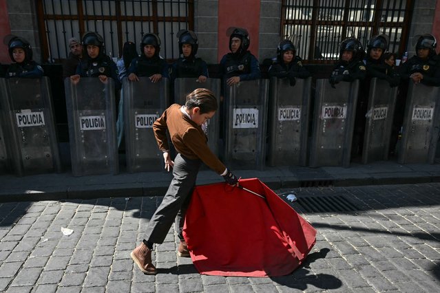 A young bullfighter performs a pass in front of a line of riot police during a protest against an initiative to ban bullfighting in the capital while it is being debated in Mexico City Congress on March 18, 2025. (Photo by Yuri Cortez/AFP Photo)