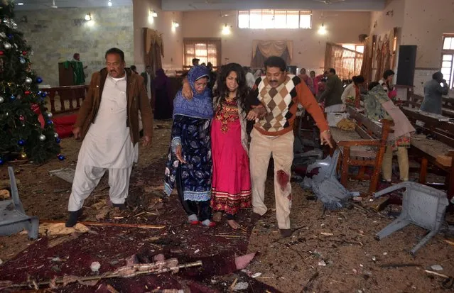 Graphic content / Pakistani Christians assist an injured worshipper after suicide bombers attacked a Methodist Church in Quetta on December 17, 2017. At least eight people were killed and 15 wounded when two suicide bombers attacked a church in Pakistan during a service on December 17, just over a week before Christmas, police said. (Photo by A. Calvin/AFP Photo)