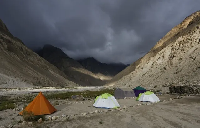 Tents stand under dark rain clouds in the valley of the river Braldu at Bardoumal near the Baltoro glacier in the Karakoram mountain range in Pakistan August 30, 2014. (Photo by Wolfgang Rattay/Reuters)