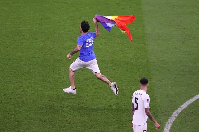 A pitch invader wearing a shirt reading “Respect for Iranian woman” holds rainbow flag during the FIFA World Cup Qatar 2022 Group H match between Portugal and Uruguay at Lusail Stadium on November 28, 2022 in Lusail City, Qatar. (Photo by Michael Steele/Getty Images)