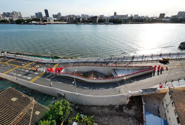Local citizens and even tourists flock to see the house, which tightly wedged between two wings of the newly opened Haizhuyong Bridge and thus is nicknamed as the Eye of Haizhuyong Bridge, Guangzhou city, south China's Guangdong province, 7 August 2020. A Chinese city has built a highway bridge around a tiny house after its owner refused to sell it to the government for a decade. The building is one of many examples of “nail houses” in China – or “dingzihu” in Mandarin – where homeowners reject compensation from a developer for its demolition. (Photo by Rex Features/Shutterstock)