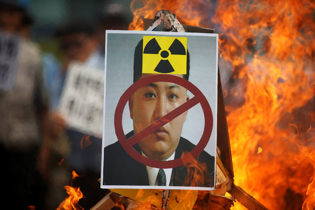 A cut-out of North Korean leader Kim Jong Un is set on fire during an anti-North Korea rally in central Seoul, South Korea, September 10, 2016. (Photo by Kim Hong-Ji/Reuters)