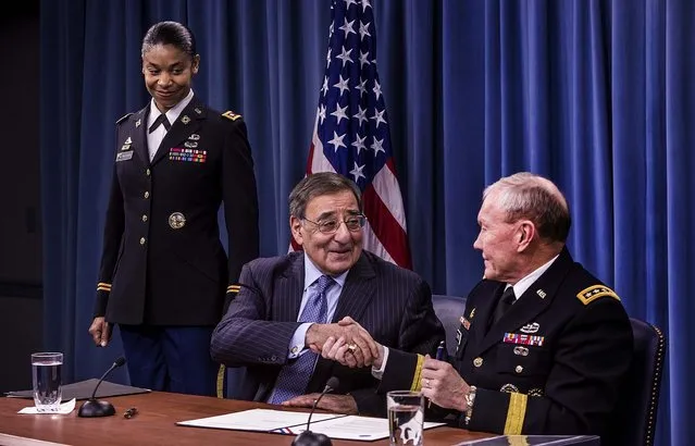U.S. Army Lt. Col. Tamatha Patterson looks on as Defense Secretary Leon Panetta and Chairman of the Joint Chiefs of Staff Gen. Martin Dempsey shake hands after signing a memo directing a policy change lifting a combat ban on women in the military, at the Pentagon in Arlington, on January 24, 2013. The decision overturns a 1994 Pentagon rule that restricted women from artillery, armor, infantry and other such combat roles. (Photo by Brendan Hoffman/The New York Times)