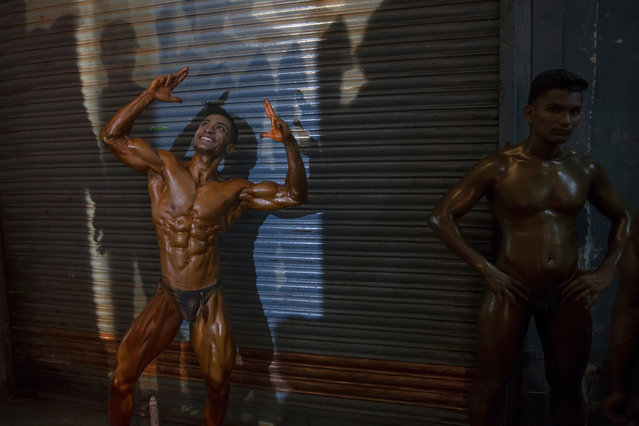 Indian body builders flex their muscles as they pose before participating in the Junior Mumbai Body Building championship in Mumbai, India, Wednesday, January 10, 2018. More than one hundred youth participated in the competition. (Photo by Rafiq Maqbool/AP Photo)