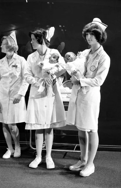 Nurses hold Linda and Brenda McCall at North Shore Hospital in Manhasset, N.Y., on Wednesday, October 12, 1977, shortly before the Siamese twins left for their home with father, Arthur, 29, and mother, Glenda, 24. The seven-month-old girls were separated in an operation at the North Shore Hospital on September 28. Doctors said at first they kept crying for each other but now they're used to being in their separate cribs. (Photo by Dan Grossi/AP Photo)