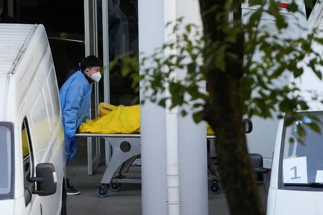 A staff member pushes a cart carrying a body bag at a funeral home, as coronavirus disease outbreaks continue in Shanghai, China on January 4, 2023. (Photo by Reuters/China Stringer Network)