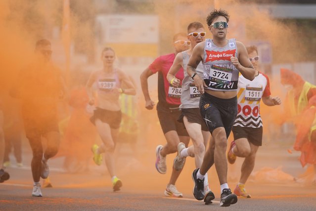 Participants get covered with colored powder during The Color Run in Moscow, Russia, Sunday, June 8, 2025. (Photo by Pavel Bednyakov/AP Photo)