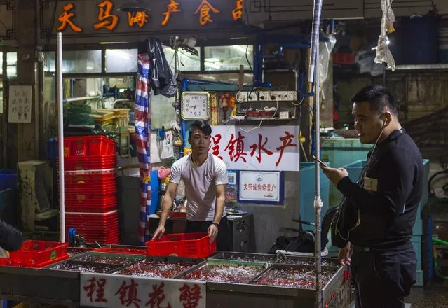 Vendor sells seafood to costumers on Huangsha Seafood Market in Guangzhou, Guandong Province, China, 18 January 2018. (Photo by Aleksandar Plavevski/EPA/EFE)