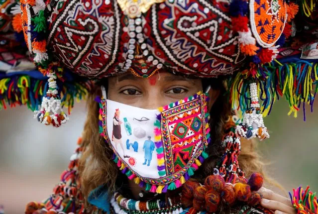 A participant in a traditional costume wearing a face mask attends a rehearsal for Garba, a folk dance, ahead of Navratri, a festival during which devotees worship the Hindu goddess Durga and youths dance in traditional costumes, amidst the coronavirus disease (COVID-19) outbreak, in Ahmedabad, India, September 12, 2020. (Photo by Amit Dave/Reuters)
