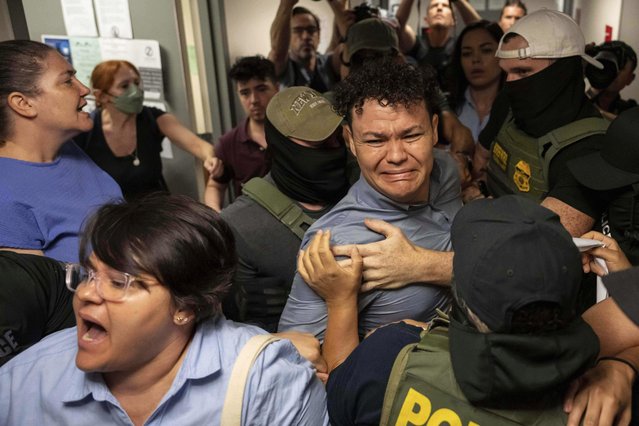 Federal agents detain Carlos Javier Lopez Benitez, center, from Paraguay as they pull away his sister, Porfiria Lopez, a U.S. citizen, left, outside immigration court at the Jacob K. Javits federal building in New York, on Wednesday, July 16, 2025. (Photo by Yuki Iwamura/AP Photo)