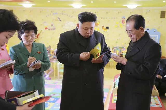 North Korean leader Kim Jong Un (C) checks a book during his visit the Pyongyang Baby Home and Orphanage on New Years Day in this photo released by North Korea's Korean Central News Agency (KCNA) in Pyongyang January 2, 2015. (Photo by Reuters/KCNA)