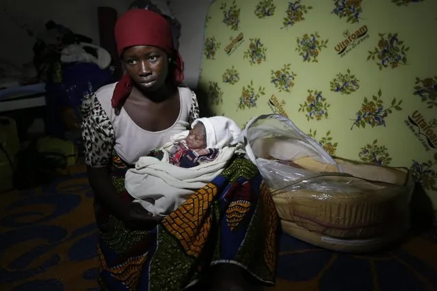 Maria Mala, a displaced woman with her new born baby Namadi, who was born Thursday morning rest at the camp for internally displaced people in Yola, Nigeria, Thursday November 27, 2014. Thousands of people have fled their homes in recent times due to Boko Haram attacks. (Photo by Sunday Alamba/AP Photo)