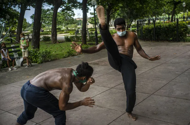 Wearing protective face masks as a precaution against the spread of the new coronavirus, Victor Rafael Torres, left, and Eiver Carbonell, train in capoeira in a park after an easing of COVID-19 related lockdown restrictions, in Havana, Cuba, Friday, July 3 , 2020. (Photo by Ramon Espinosa/AP Photo)