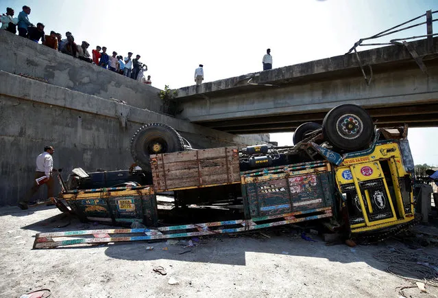Police officers inspect the site of an accident after a truck carrying wedding party guests plunged into a dry riverbed, in Ranghola village in Bhavnagar district, in the western Indian state of Gujarat, India, March 6, 2018. (Photo by Amit Dave/Reuters)