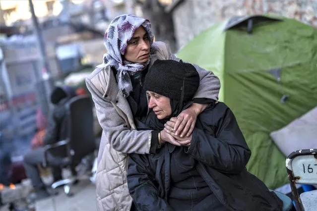 A family mourns moments after a body of a relative was pulled out of a building destroyed during the earthquake in Antakya, southeastern Turkey, Tuesday, February 14, 2023. The death toll from the earthquakes of Feb. 6, that struck Turkey and northern Syria is still climbing. (Photo by Bernat Armangue/AP Photo)