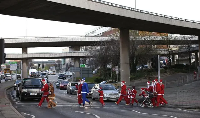 People dressed as Santa Claus cross a road as they make their way to the start of the annual Santa Dash in Liverpool, northern England December 7, 2014. (Photo by Phil Noble/Reuters)