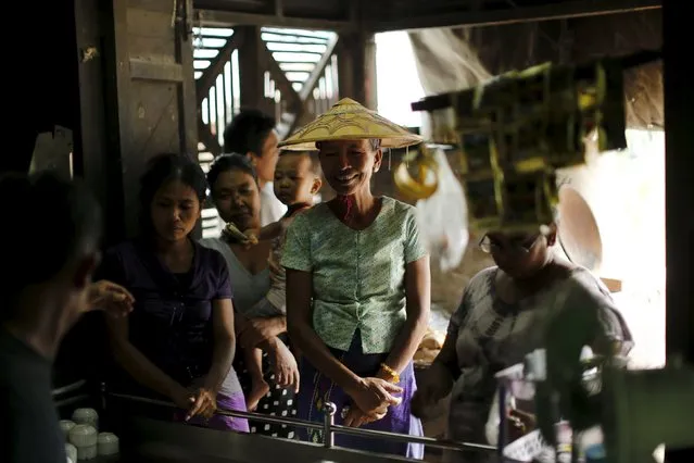 Women wait to buy tea at a market in Mandalay, Myanmar, October 7, 2015. (Photo by Jorge Silva/Reuters)